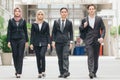 Young and confident business people walking together in a modern office corridor Royalty Free Stock Photo