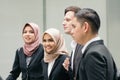 Young and confident business people walking together in a modern office corridor Royalty Free Stock Photo