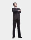 Young, confident businessman looking up with arms crossed, studio shot, full length Royalty Free Stock Photo