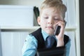 Young confident executive businessman boss boy in office talks on the phone sitting at the desk with laptop. Royalty Free Stock Photo