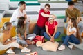 Young confident male safety instructor teach students to bandage the head