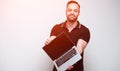 Young confident man holding laptop over white background. With sunlight effect Royalty Free Stock Photo