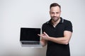Young confident man pointing on laptop over white background Royalty Free Stock Photo