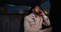 Young confident man talking over phone while sitting in taxi Royalty Free Stock Photo