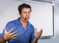 Successful man working as motivational speaker and business management coach talking to audience in conference room using headset Royalty Free Stock Photo