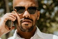 Young confident urban professional man using smart phone. African american male businessman using mobile smartphone for Royalty Free Stock Photo