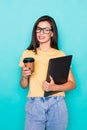 Young woman with coffee cup and holding folder  on turquoise background Royalty Free Stock Photo