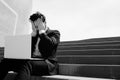 Young confidental businessman wearing suit and using modern laptop outdoors. Successful banker working outside during Royalty Free Stock Photo