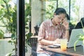 Young confused Asian woman working on laptop in cafe bar, thinking solving online problem solution Royalty Free Stock Photo