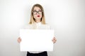 Young confused business woman in eyeglasses holding blank sheet of paper for announcement isolated white background Royalty Free Stock Photo