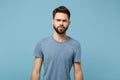Young confused pensive displeased man in casual clothes posing isolated on blue wall background, studio portrait. People Royalty Free Stock Photo