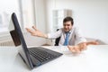 Young confused and unsure man is working with laptop in office Royalty Free Stock Photo