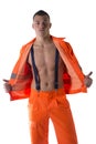 Young construction worker with orange suit open on naked torso