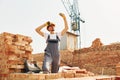 Young construction worker in uniform is busy at the unfinished building Royalty Free Stock Photo