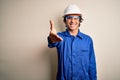 Young constructor man wearing uniform and security helmet over isolated white background smiling friendly offering handshake as
