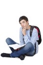 Young contemplative male student sitting on floor