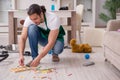 Young male contractor cleaning the flat after kids` party