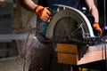 Close-up of carpenter using electric circular saw to cut wood planks Royalty Free Stock Photo