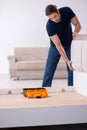 Young male contractor installing furniture at home