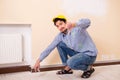 The young contractor sanding wall down with sandpaper