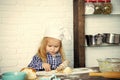 The young cook. The concept of the future profession. Child cook in chef hat rolling dough with wooden pin Royalty Free Stock Photo