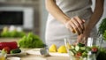 Young cooking girl squeezing fresh lemon juice in salad bowl, vegan, vegetables