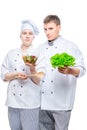 young cooks in suits with salad in hands Royalty Free Stock Photo