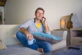 Young cool attractive and happy man sitting at living room sofa couch networking relaxed talking having conversation on mobile pho Royalty Free Stock Photo