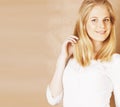 Young cool blong teenage girl messed with her hair smiling close up on warm brown background, lifestyle people concept Royalty Free Stock Photo