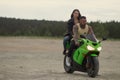 Stylish couple on motorbike on beach