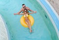 Young cople having fun in the water with yellow mattress.