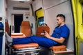Young corpsman in uniform sits with phone in the ambulance car