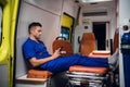 Young corpsman sitting with his phone in the ambulance car