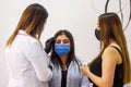 Young cosmetologist with a medical mask working on his client