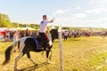 A young Cossack rides a horse and saber cuts a bottle of water