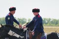 Young Cossacks in traditional costumes on horseback