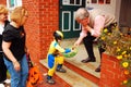 A young costumed boy grabs a handful of treats on Halloween