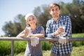 Country couple of farmers drink milk in field near fenc Royalty Free Stock Photo