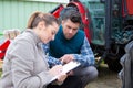 young country woman give to man tractor driver notes Royalty Free Stock Photo