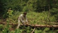 Young countryman woodcutter in traditional ukrainain clothes in the green forest of Carpathian mountains