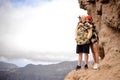 Young coupla standing on the rock in the background of a beautiful landscape in the day time