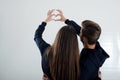 A young couple standing back looking at the white wall shows to the heart Royalty Free Stock Photo