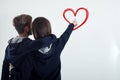 A young couple standing back looking at the white wall shows to the heart Royalty Free Stock Photo