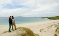 Young couple admiring a remote landscape with white sand beach