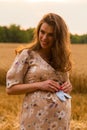Young couple awaiting baby embrace the field Royalty Free Stock Photo