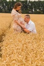 Young couple awaiting baby among the wheat field Royalty Free Stock Photo