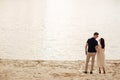 Young couple back standing near to the lake on nature. Romantic man and woman are hugging outdoors. Happy moments together. love Royalty Free Stock Photo