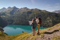 Young couple with backpack reading a map in the swiss alps. Lake ritom as background Royalty Free Stock Photo