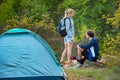 Young couple backpackers camping trip in forest at summer weekend. Travel, tourism, hike and people concept. Royalty Free Stock Photo