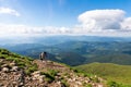 Young couple with backpacks traveling together in mountains. Happy hipster man kissing his girlfriend on the top Royalty Free Stock Photo